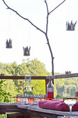 Candle lanterns hand-made from tin cans hung above benches on natural terrace