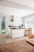 Island counter in white, open-plan fitted kitchen