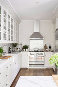 Country house kitchen all in white with stucco ceiling and wooden floor