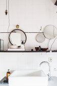 Washstand with countertop sink below shelf in white bathroom