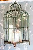 Three candles in suspended birdcage