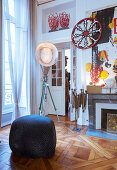 Pouffe, designer lamp and collection of artworks in period apartment