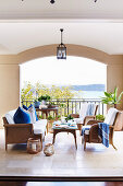Elegant rattan furniture on a covered veranda with sea views