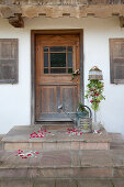 Willkommensstrauss aus langstieligen Rosen und Frauenmantel an der Haustür