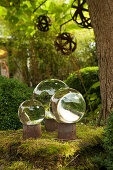 Glass spheres on rusty metal stands decorating garden
