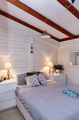 Bedroom with white painted wooden paneling in the attic