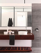 Clear lines and wooden washstand in masculine bathroom