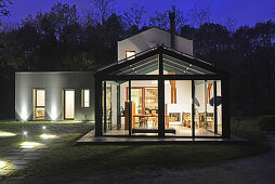 Haus mit Glasfassade in Abendbeleuchtung