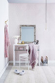 Mirror with silver frame on white dressing table in the bedroom