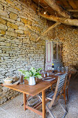 Gedeckter Tisch in alter Scheune mit Natursteinwand
