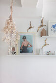 Pictures on shelves and bird ornaments on white walls
