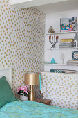 Polka-dot wallpaper on wall and chest of drawers in bedroom