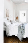 Double bed in white bedroom