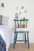 Stacked magazines on old blue chair used as bedside table