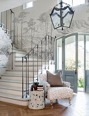 Elegant grey-and-white foyer with landscape painted along staircase