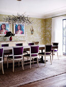 Long dining table with bordeaux-red upholstered chairs in the dining room with wallpaper