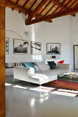 Modernes Sofa im Wohnzimmer mit offener Holzdecke