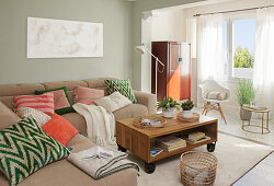 Colourful cushions on sofa in living room in muted shades