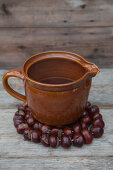 Ceramic jug on trivet handmade from horse chestnuts