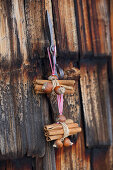 Bundles of cinnamon sticks and nuts hung on rustic wooden door