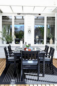 Set table and black chairs on roofed terrace