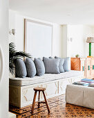 Elegant bench with cushions against white wall