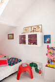 Brightly coloured accessories in child's attic bedroom