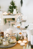 White chocolate apples, cinnamon swirls on cake stand and Christmas decorations on table