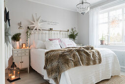 Double bed and Christmas decorations in bright bedroom