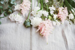 Delicate pink and white flowers and poppy seed heads