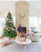 Family in pastel-colored living room with Christmas tree