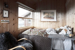 Gemütliches Schlafzimmer mit Doppelbett und Holzverkleidung