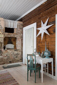 Console table below white star on wall in front of rustic brick fireplace