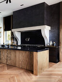 Designer kitchen with black wall and wood and granite island
