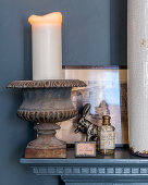 White candle in metal urn and vintage-style ornaments