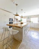 Large, bright country-house kitchen with stone-flagged floor