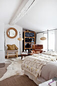 Blanket on bed, classic leather armchair, standard lamp and cabinet in bedroom