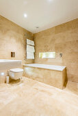 Sand-coloured tiles in spacious bathroom