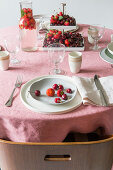 Gedeckter Tisch mit Beeren und Tischdecke in Rosa