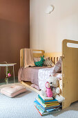 Child's bed in simple child's bedroom in natural shades
