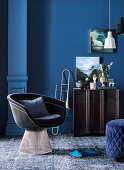 Klassiker Lounge Sessel, Trompete neben Siedeboard vor blauer Wand im Wohnzimer