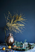 Festive arrangement of natural materials with larch branch against blue wall