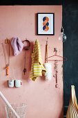 DIY coat rack made from large nails on pink wall