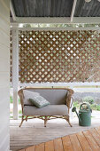 Rattan sofa on veranda with wooden floor and screen