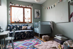 Hellblaues Kinderbett, Sofa und Spieldecke im Babyzimmer