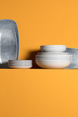Plates and trays on ledge on yellow wall