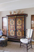 Antique painted cabinet flanked by two louvre windows