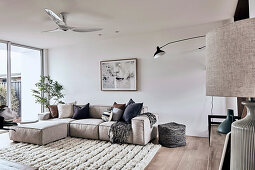 Modernes Sofa im Wohnzimmer in Naturtönen mit Hochflorteppich