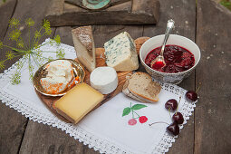 Cheese board and cherry compote on rustic table