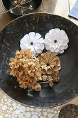 Dried hydrangea and origami flowers in dish